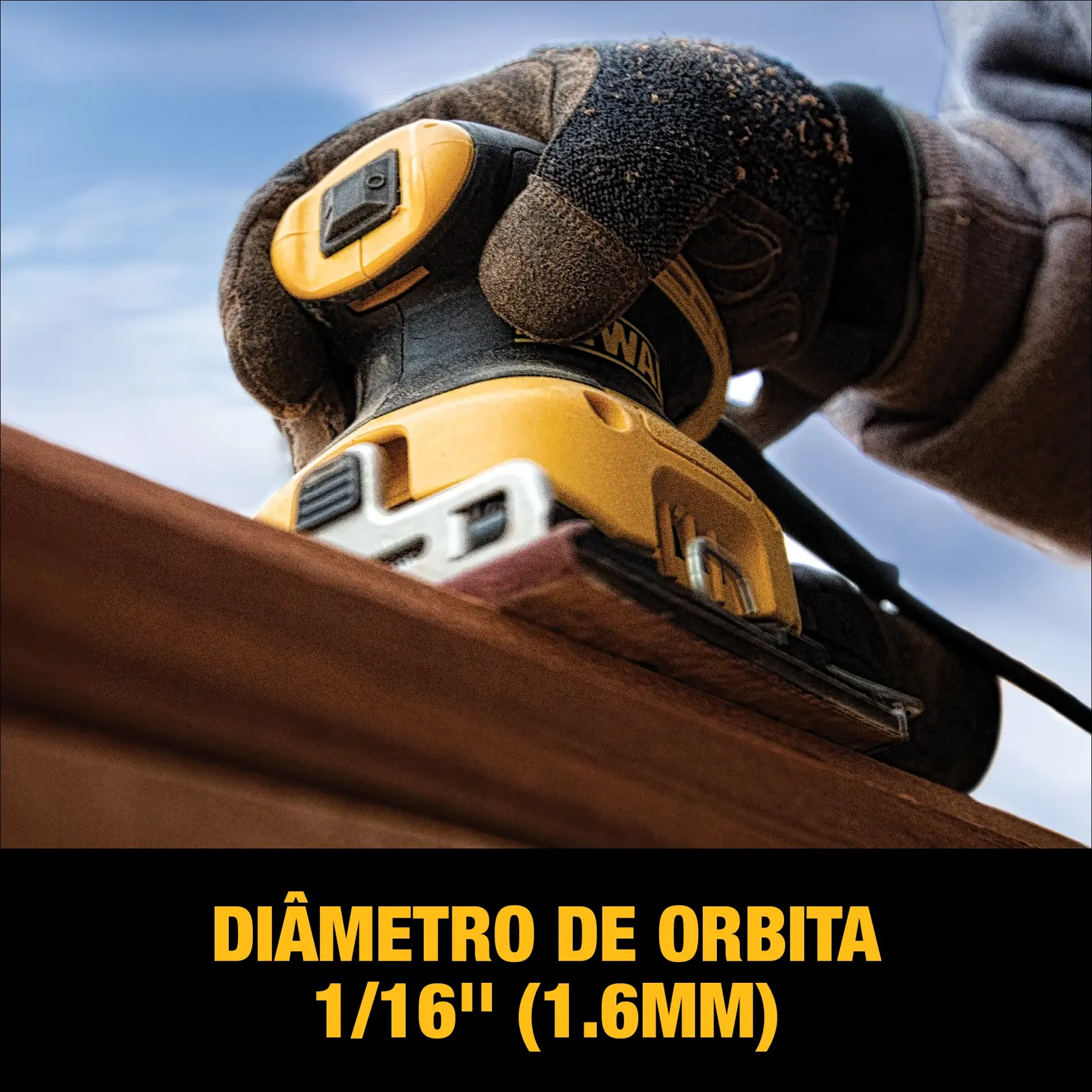 Uma pessoa usando uma lixadeira elétrica DEWALT em uma superfície de madeira dentro de uma oficina ou garagem. A lixadeira é amarela e preta, e a mão da pessoa está segurando-a contra a madeira.