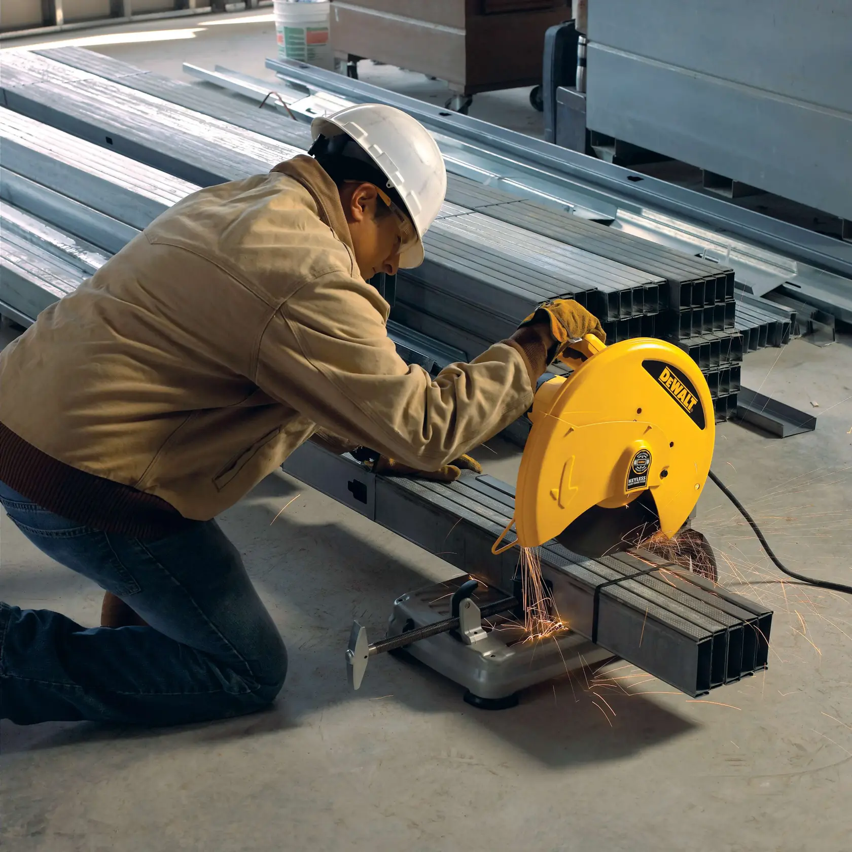Eine DEWALT Metalltrennsäge mit großem gelbem Schutz, montiert auf einem stabilen silbernen Sockel mit einer Klemme zum Fixieren von Materialien. Die Säge ist für präzises Schneiden von Metallwerkstücken ausgelegt.