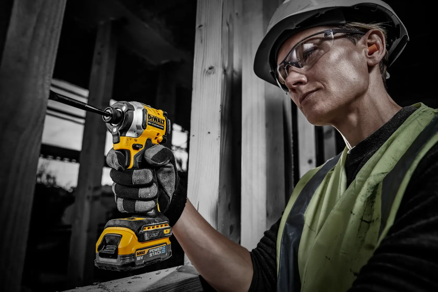 Trabalhador usa ferramenta DEWALT com bateria DCBP034 em obra, rosto desfocado para privacidade.