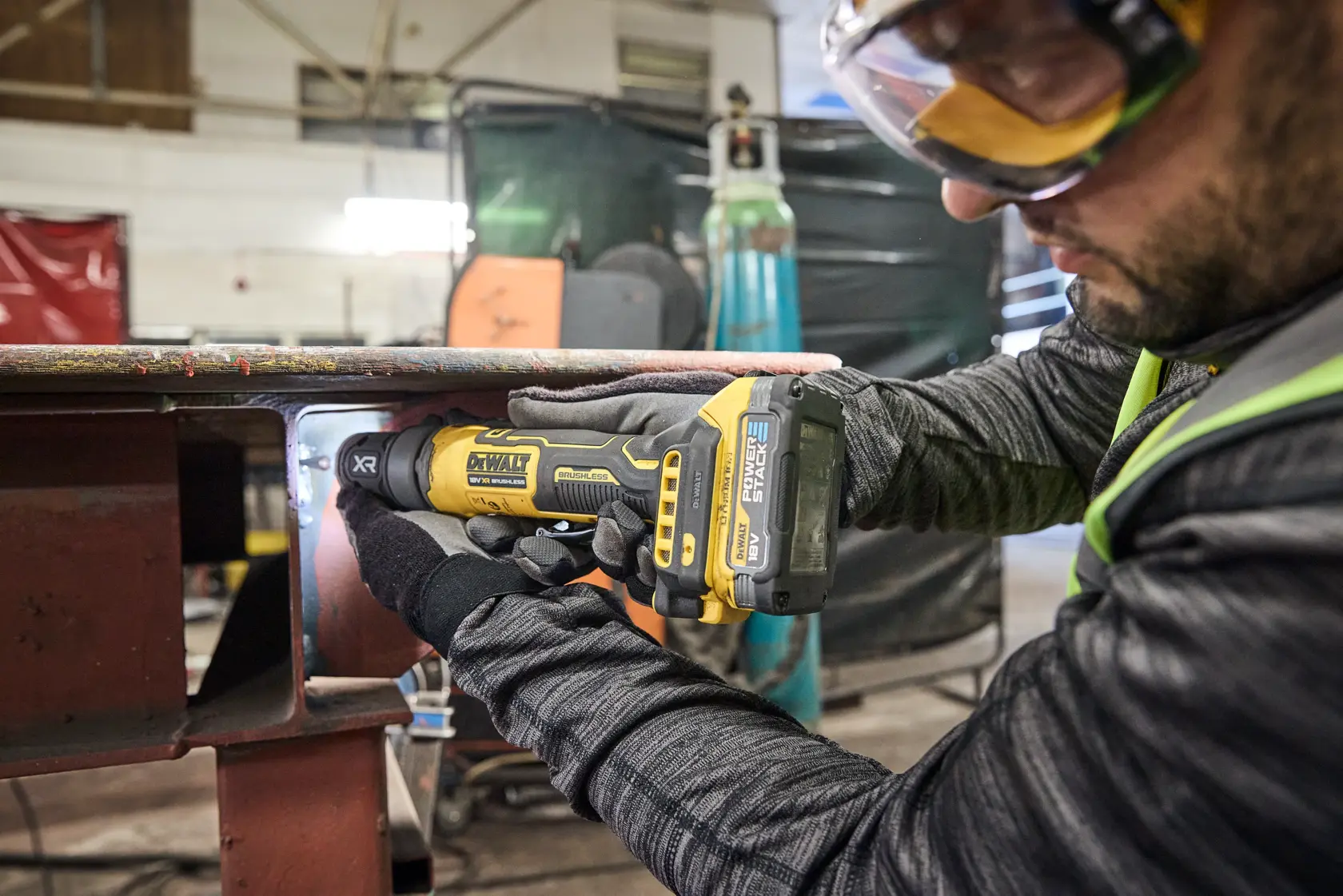 DEWALT DCG420N-XJ, DCG420N esmeril em oficina. Operário com luvas usa ferramenta. Categoria fotografia.