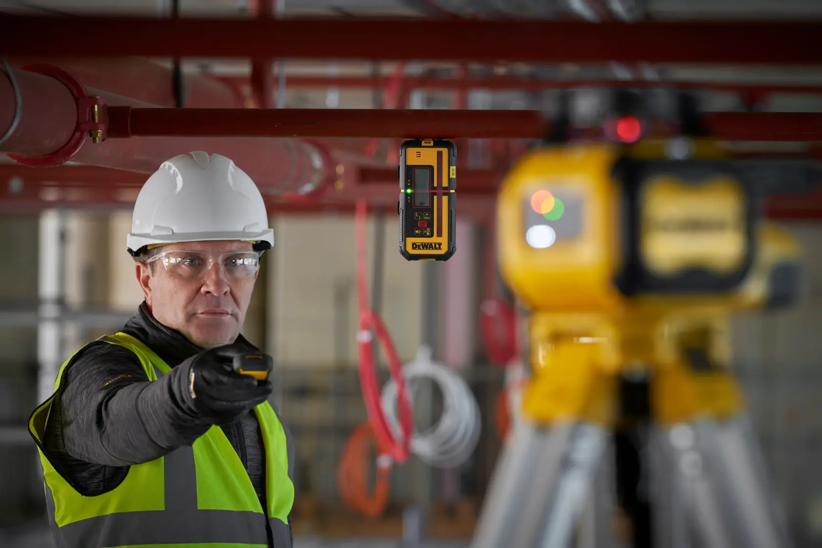 Trabalhador usa DEWALT DCLE15211R, DCLE15211R-QW detector de laser em obra. Produto de fotografia.