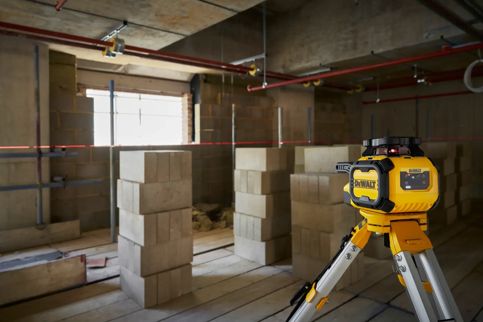 DEWALT DCLE15211R, DCLE15211R-QW nível a laser no tripé em obra com blocos.