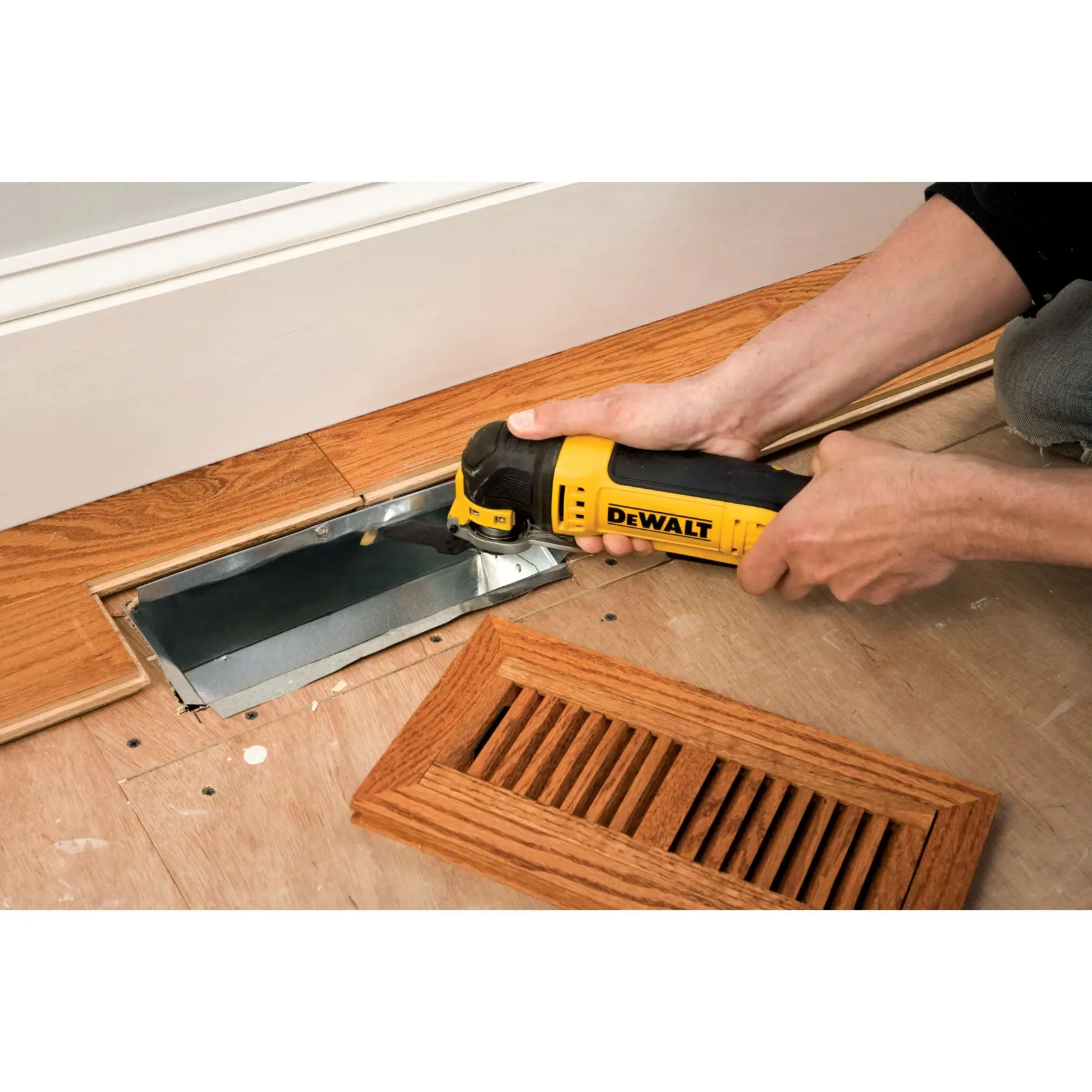 Herramienta DEWALT DT20702 corta suelo de madera junto a una rejilla de ventilación, cubierta al lado.