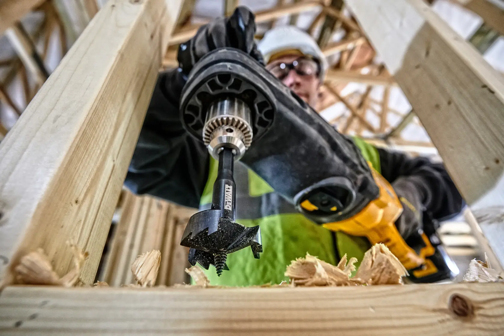 Broca DEWALT DT4578 perforando vigas de madera en un entorno de construcción.