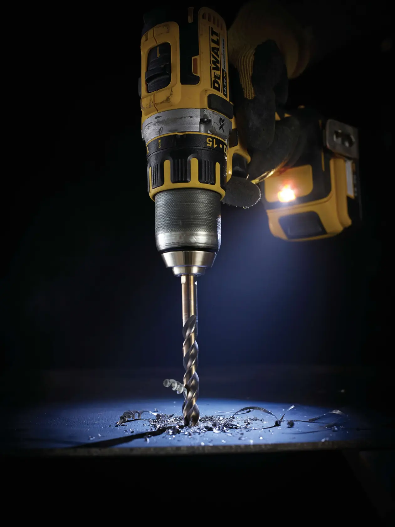 Taladro DEWALT con broca, SKUs: DT5060-QZ, DT5060. Virutas metálicas bajo el taladro.