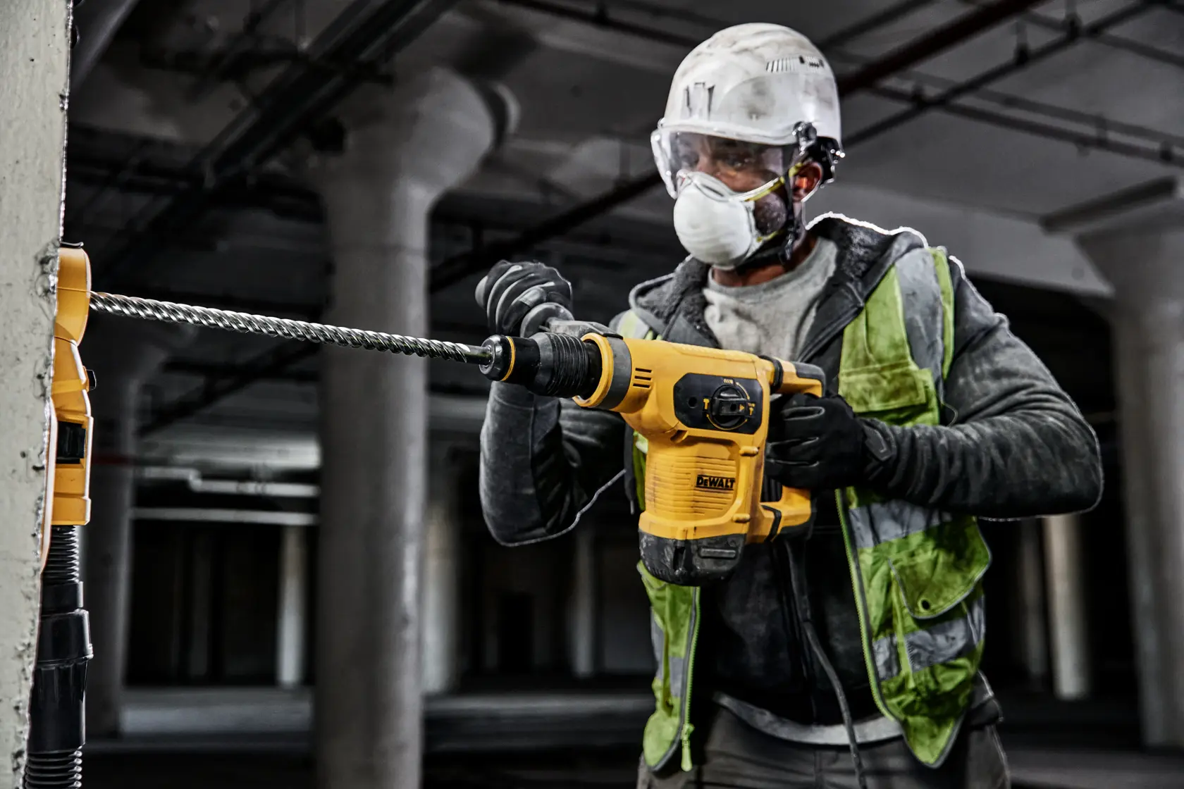 Persona utiliza martillo DEWALT con broca DT60827 sobre concreto en obra de construcción.