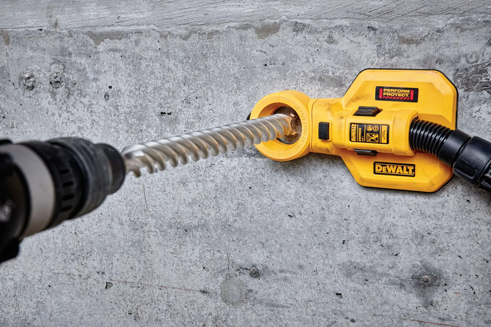 Accesorio DEWALT DT60846 usado en pared de concreto con broca en espiral.