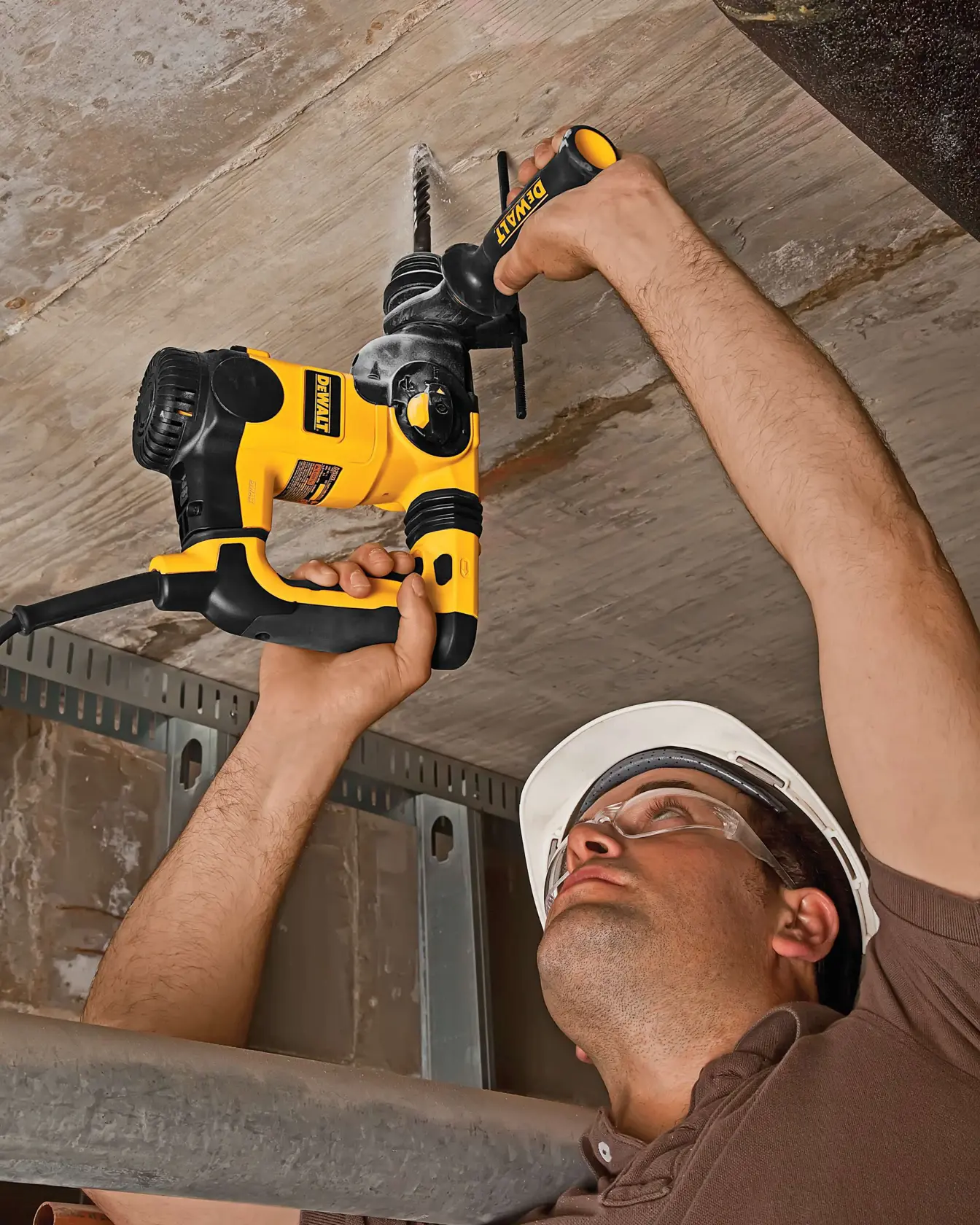 Persona trabajando en el techo usando taladro amarillo DEWALT, herramienta ideal para construcción.