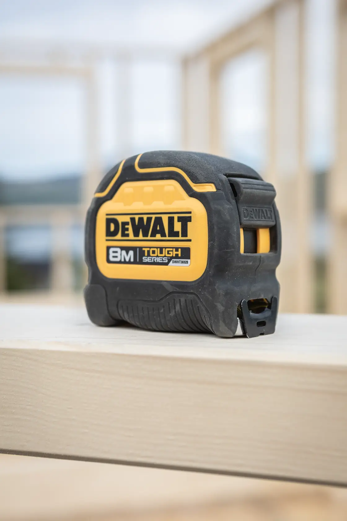 Fita métrica DEWALT 8m Tough Series sobre uma tábua de madeira na obra.